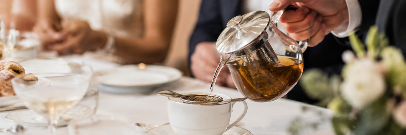 Pouring tea through a silver strainer